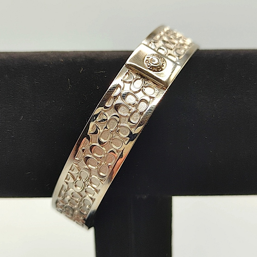 COACH Silver Bangle Bracelet with Signature Classic “C” Logo Print.